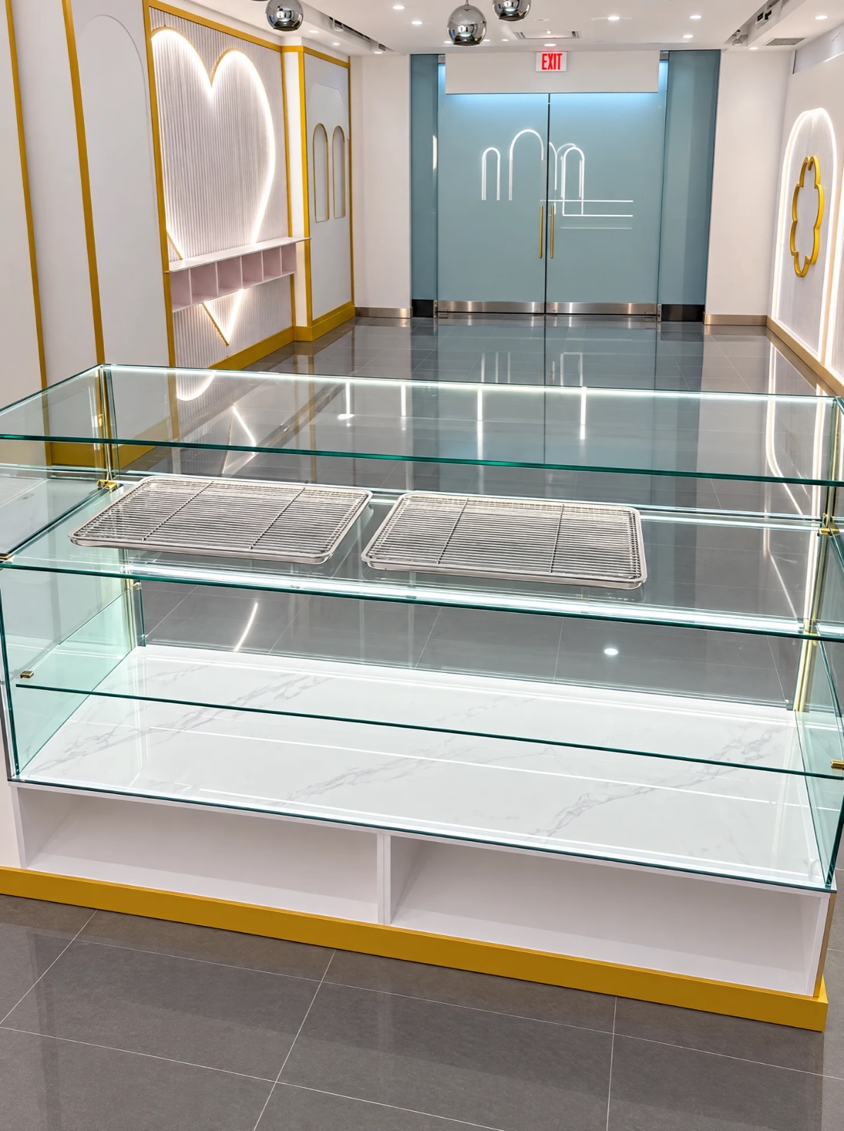 Marry Me Mochi interior — custom glass-and-marble display case and branded doors, built by Atena Construction