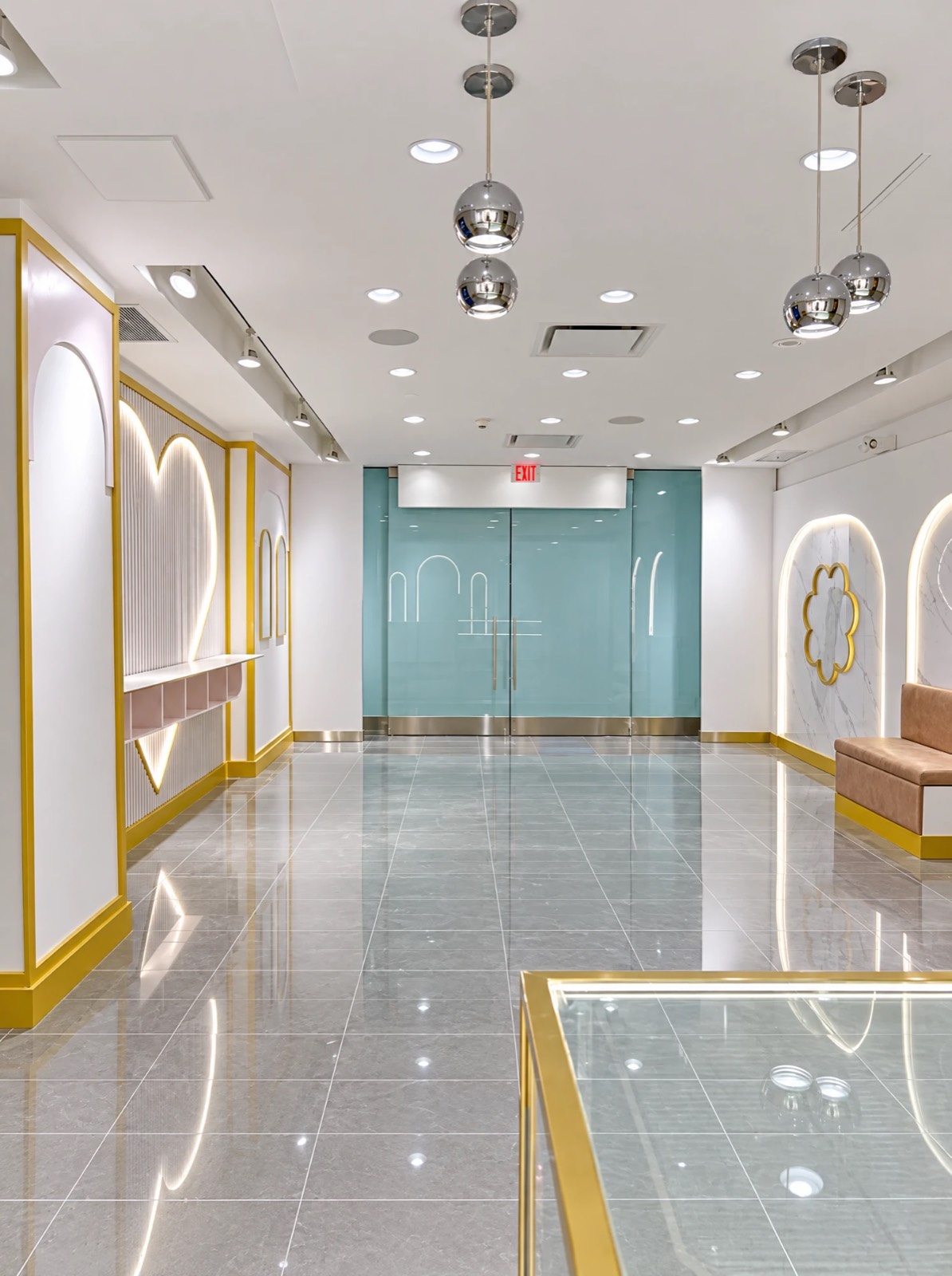 Marry Me Mochi interior — backlit heart feature wall, arched marble niches and gold trim by Atena Construction